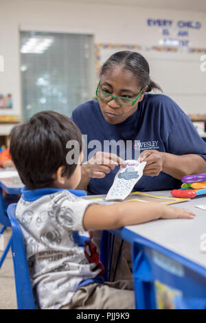 Houston, Texas - l'enseignant travaille avec un enfant dans le pré-K de classoom Wesley Community Centre Programme d'éducation de la petite enfance. Banque D'Images
