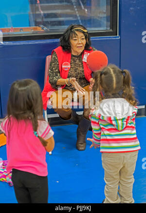 Houston, Texas - Un bénévole avec le Senior Corps favoriser les grands-parents programme fonctionne avec quatre ans d'enfants dans la salle de sport pendant ce communauté Wesley Banque D'Images