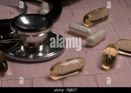 Prend le graphique avec stéthoscope et comprimés de près. La santé cardiaque concept médical. Moniteur cardiaque ECG EKG ou examen médical. Banque D'Images
