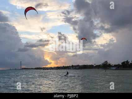 Silhouette d'un kite surfer dans l'océan le long de la côte sud de la Floride au coucher du soleil. Banque D'Images