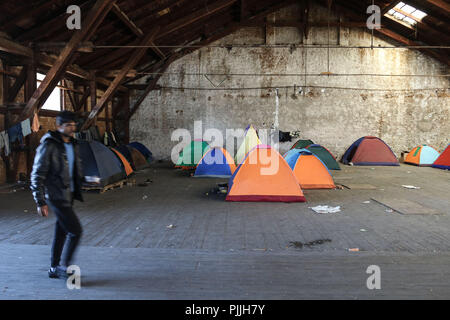 Patra, Achaïe, Grèce. Mar 29, 2018. Un migrant vu marcher à côté des tentes à l'intérieur de l'abri.Les Migrants et les réfugiés à trouver refuge dans un camp de fortune qu'ils ont pris à un ancien marchand à côté de port de Patras. Le port de la ville est devenue un important point de départ pour les sans-papiers et les réfugiés qui tentent de se rendre en Italie et de là à d'autres pays en Europe. Essayez les migrants pour accéder au port et se cachent dans les camions en attente d'être envoyé à l'Italie par ferry. Menelaos Crédit : Michalatos SOPA/Images/ZUMA/Alamy Fil Live News Banque D'Images