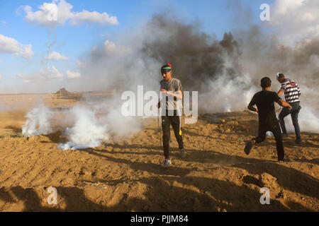 Gaza, la Palestine. Sep 7, 2018. Palestiniens vu courir loin de la fumée des gaz lacrymogènes tirés par les forces israéliennes au cours des affrontements.Des affrontements entre les forces israéliennes et les citoyens palestiniens au cours d'une manifestation contre la décision du Président Trump à reconnaître Jérusalem comme capitale d'Israël. La réserve était intitulé : retour malgré votre nez Trump. Credit : Ahmad Hasaballah SOPA/Images/ZUMA/Alamy Fil Live News Banque D'Images