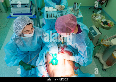 Chirurgie de liposuccion cosmétiques dans la salle d'opération, groupe de chirurgiens travaillant avec canule Banque D'Images