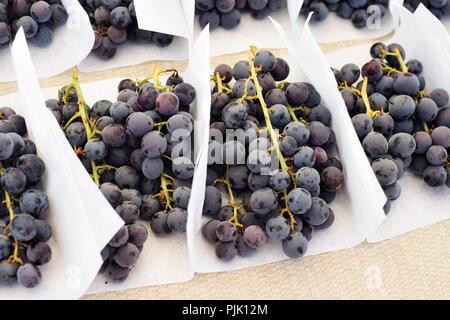 Grappes de raisin s'asseoir sur une table dans une échoppe de marché au marché de fermiers Banque D'Images