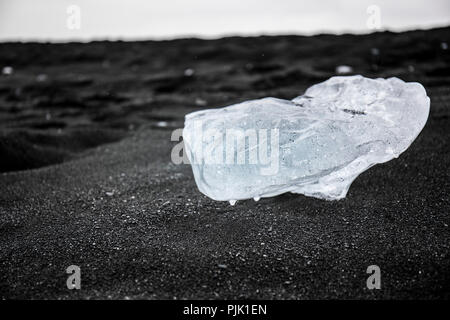 Bloc de glace du glacier sur le noir profond dans le sable, l'Islande Jökulsárlón Banque D'Images