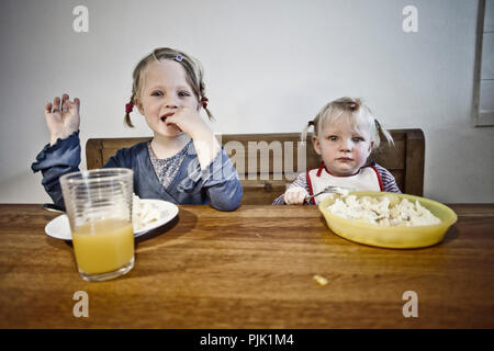 Deux jeunes filles en train de dîner table en bois Banque D'Images