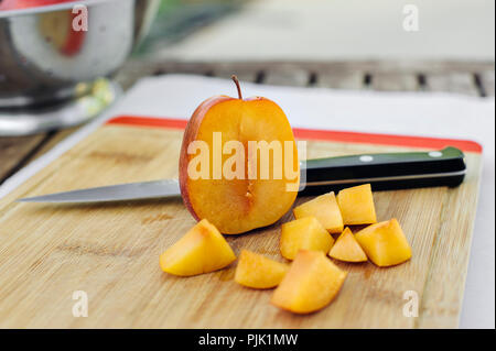 Visage d'un amigo pluot est coupé et haché morceaux sur une planche à découper Banque D'Images