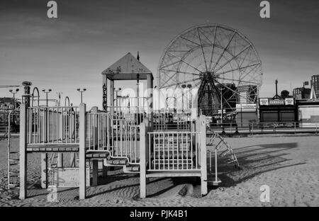 Jeux pour enfants sur la plage de Coney Island, Brooklyn, New York City, USA, en arrière-plan le Luna Park avec grande roue, Banque D'Images