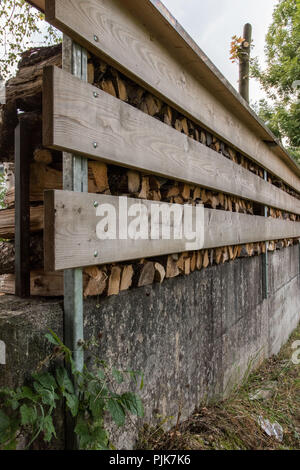 Bois de chauffage, empilées de façon décorative sur un mur de béton, utilisé l'écran arrière, asprivacy Banque D'Images