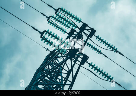 Tour en acier de type treillis fragment supérieur sur ciel nuageux comme faisant partie de la ligne à haute tension. Détails ligne électrique aérienne, photo dans les tons bleus Banque D'Images