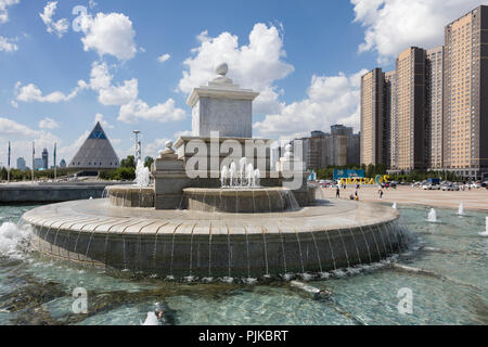 Astana, Kazakhstan, le 3 août 2018 : Fontaine sur la place de l'indépendance avec des palais de la paix et de la réconciliation dans l'arrière-plan Banque D'Images