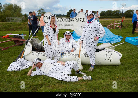 Photo de groupe de gens habillés en costumes de chien en face de leur radeau faits maison à la Plaine de jeux Thorney Somerset en Angleterre Banque D'Images