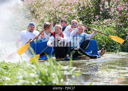 People rowing un radeau le long d'une rivière et se mettre à l'eau à la Plaine des jeux, Thorney, Somerset, Angleterre Banque D'Images