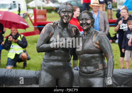 Deux femmes aux prises avec une foule de boue derrière à la Plaine des jeux, Thorney, Somerset, Angleterre Banque D'Images