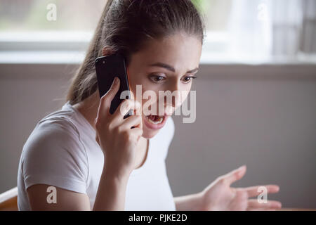 Choqué femme dévastée par de mauvaises nouvelles entendu par téléphone Banque D'Images