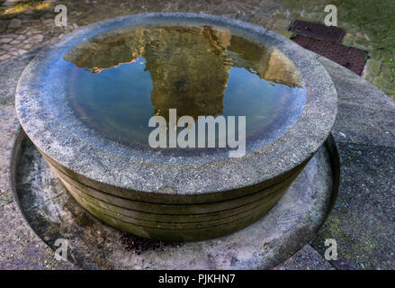 Fontaine à la place de l'Eglise, reflet de l'église Saint-Martin construite au XI siècle Banque D'Images