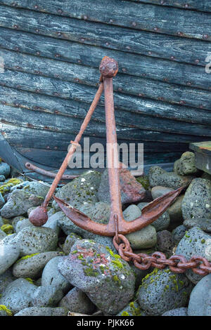 L'Islande, old rusty l'ancre en face de coque de bateau, pierres, chaîne d'ancre, Banque D'Images