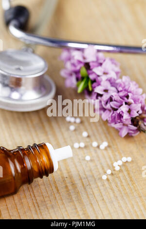 Globules lipidiques se situent sur une table à côté d'une fleur de Daphné et d'un stéthoscope, Banque D'Images