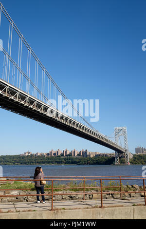 Un touriste prend une photo de la George Washington Bridge à partir de Fort Lee, NJ avec la rivière Hudson, Little Red Phare et la ville de New York. Banque D'Images