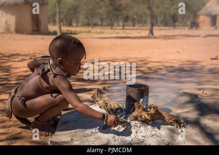 Jeune fille Himba fait feu dans un village Himba en Namibie Banque D'Images