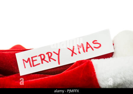 Carte avec Joyeux Noël écrit dessus sur rouge santa la haine. L'espace vide prêt pour votre texte ou logo. Banque D'Images