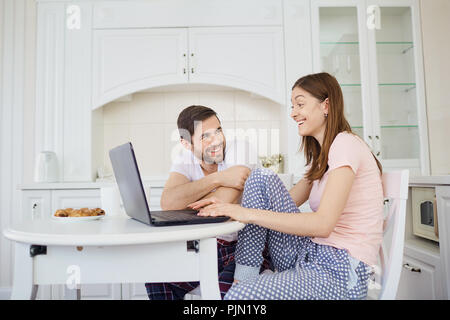 Un jeune couple est le petit-déjeuner à la table de travail, avec un Banque D'Images