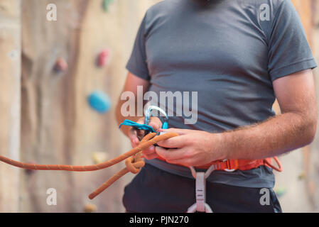 Rock Wall climber wearing harnais de sécurité et le matériel d'escalade indoor, close-up de droit Banque D'Images