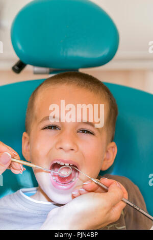 L'examen de dentiste dents du petit garçon dans une clinique. Close up of boy après avoir examiné ses dents par un dentiste. Un enfant à la clinique dentaire. Avec les médecins Banque D'Images