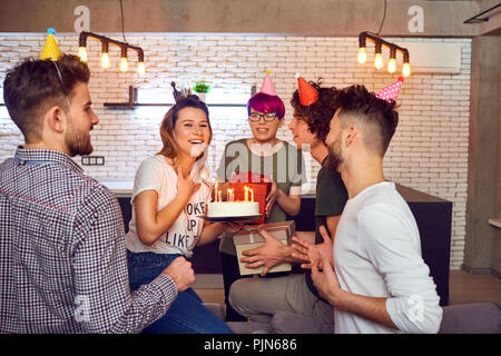 Les amis avec un gâteau avec des bougies fête anniversaire. Banque D'Images