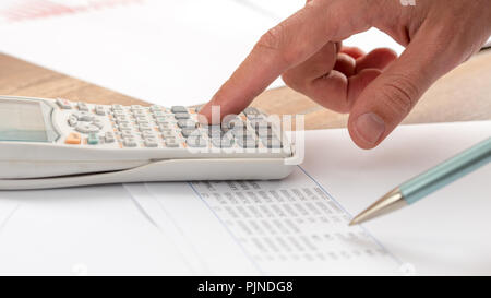 Gros plan du comptable de faire un calcul sur une calculatrice blanc. Banque D'Images