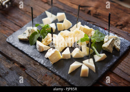 Vue de dessus de fromages sur fond noir plaque en pierre Banque D'Images