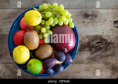Directement au-dessus de coup de bol rempli de fruits frais sur une table en bois rustique Banque D'Images