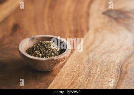 Herbes de Provence séchées pour l'assaisonnement dans un bol en bois sur la table, l'accent peu profondes Banque D'Images