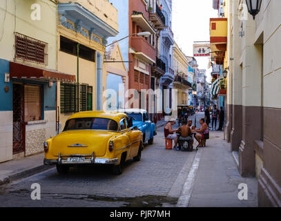 La HAVANE, CUBA - CIRCA MAI 2017 : vieux classique des voitures dans les rues de La Havane avec des personnes jouant Domino. Banque D'Images