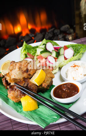 Un repas de poulet Karaage avec red chili trempette de haricots et de paprika yaourt servi avec un mélange de salade fraîche Banque D'Images