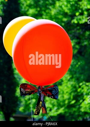 Des ballons rouges et jaunes sur fond vert Banque D'Images