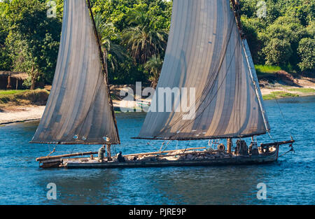 Voilier de travail traditionnel avec d'anciennes voiles avec les trous du transport de grosses pierres avec des hommes en robes traditionnelles égyptiennes, Nil, l'Egypte, l'Afrique Banque D'Images