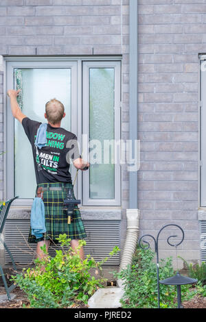 L'homme à un kilt windows se lave dans un complexe d'appartements. Banque D'Images