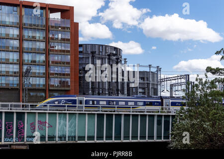 Train à grande vitesse Eurostar passant des immeubles d'habitation modernes à King's Cross, Londres Angleterre Royaume-Uni UK Banque D'Images