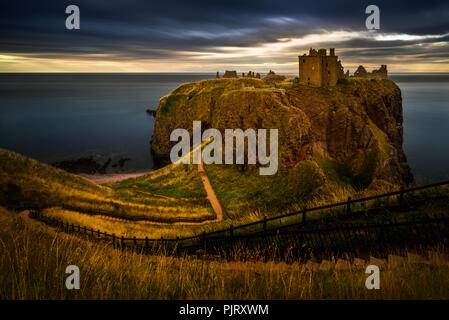 Dunnottar Castle sur de hautes falaises au coucher du soleil la lumière, Ecosse Banque D'Images