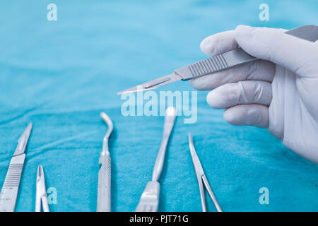 Close up hand holding surgical instruments dans la salle d'opération. Banque D'Images