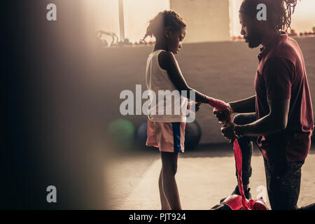 Boxe bandage mettre sur les mains d'un boxeur pour enfants. Kid boxe enroulant ses mains avant de porter des gants de boxe. Banque D'Images