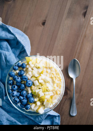 Vue de dessus du bol avec millet bouillie sur fond de table en bois. Porridge de millet bio avec Blueberry et de poire, l'espace de copie pour le texte. Soft focus, sh Banque D'Images