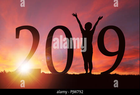 2019 Nouvelle année silhouette d'une fille avec les mains posées lors du lever ou du coucher du soleil d'or avec l'exemplaire de l'espace. Concept de joie, louange, adoration, liaison avec