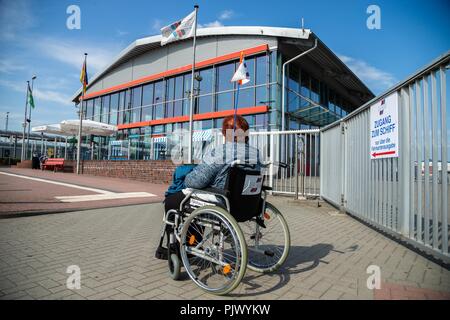 L'Emden, en Allemagne. 05 Sep, 2018. Une femme dans un fauteuil roulant est à la station de ferry en face d'une barrière métallique, sur lequel une pancarte avec l'inscription 'Accès au navire - uniquement via la billetterie' est joint. (Sur dpa "sévèrement handicapés lutte pour l'homme - aussi comme des passagers du traversier du 09.09.2018) Crédit : Mohssen Assanimoghaddam/dpa/Alamy Live News Banque D'Images