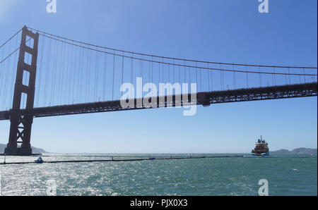 San Francisco, USA. 05Th Nov, 2018. 08.09.2018, USA, San Francisco : la première collecte des déchets flottants 'périphérique' Nettoyage de l'océan est remorqué par un navire sous le Golden Gate Bridge. Comme les tentacules, les extrémités de la 600 mètres de long tuyau en plastique du système de nettoyage sont de mentir autour de montagnes de déchets plastiques - initialement sur le pacifique entre la Californie et Hawaï. Crédit : Barbara Munker/dpa/Alamy Live News Banque D'Images