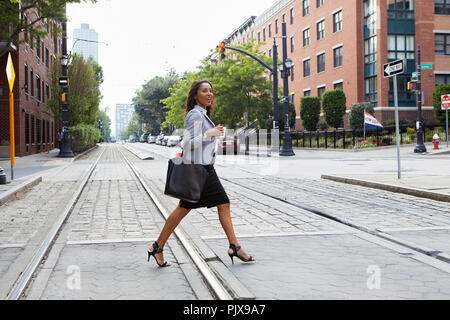 Businesswoman crossing light rail voies Banque D'Images