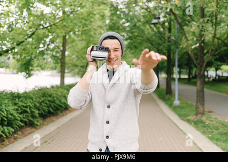 Jeune homme de prendre des photos avec l'appareil photo instantané, Vancouver, Canada Banque D'Images