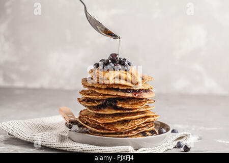 Vegan pile de pancakes aux myrtilles avec du beurre d'arachides et le sirop. Concept de l'alimentation propre. Banque D'Images