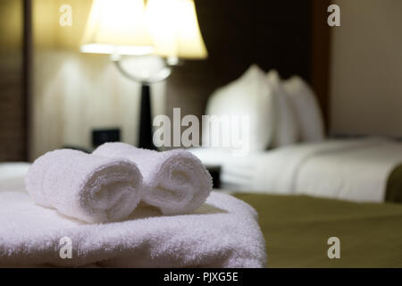 Drap de bain blanc sur le lit dans la chambre d'hôtel Banque D'Images